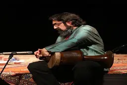 کمانچه‌ای بر دوش و چمدانی در دست