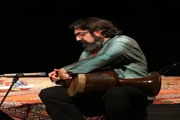 کمانچه‌ای بر دوش و چمدانی در دست