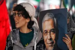 عکسی که فارس از یک دختر با عکس سردار باقری در تجمع شبانه تهران منتشر کرد