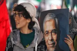 عکسی که فارس از یک دختر با عکس سردار باقری در تجمع شبانه تهران منتشر کرد