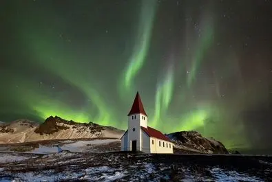 شفق قطبی بر فراز کلیسایی در ایسلند